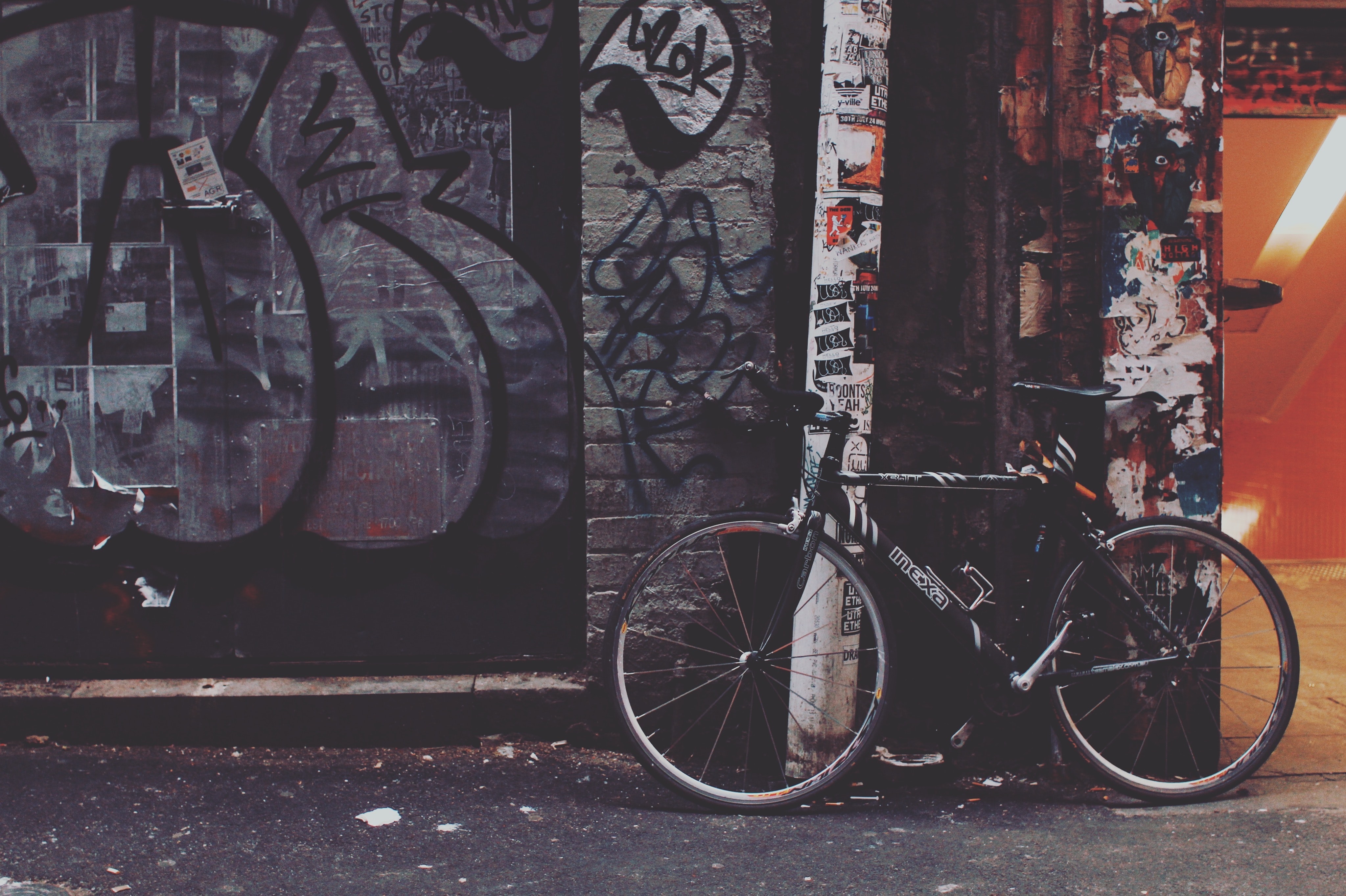 A bicyle against a wall with graffiti